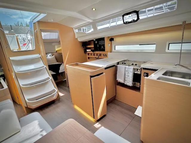 Slide: The Image of Modern interior of 2023 Jeanneau Sun Odyssey 440 yacht, featuring sleek kitchen and seating area. - 2