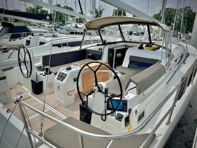 Slide: The Image of 2023 Jeanneau Sun Odyssey 440 sailboat with dual steering wheels and spacious cockpit. - 23