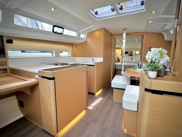 Slide: The Image of Interior of 2023 Jeanneau Sun Odyssey 440 yacht, featuring modern kitchen and dining area. - 26