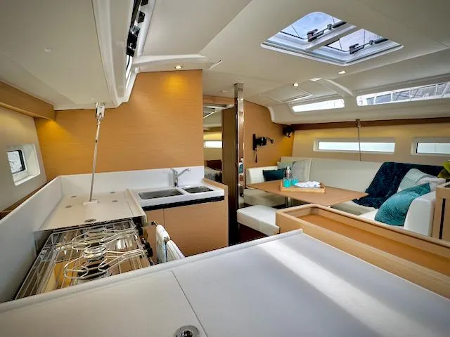 Slide: The Image of Modern interior of 2023 Jeanneau Sun Odyssey 440 yacht with kitchen and seating area. - 32