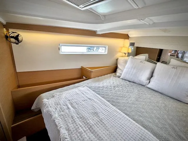 Slide: The Image of Luxurious cabin interior of 2023 Jeanneau Sun Odyssey 440 yacht, featuring cozy bedding and modern design. - 35