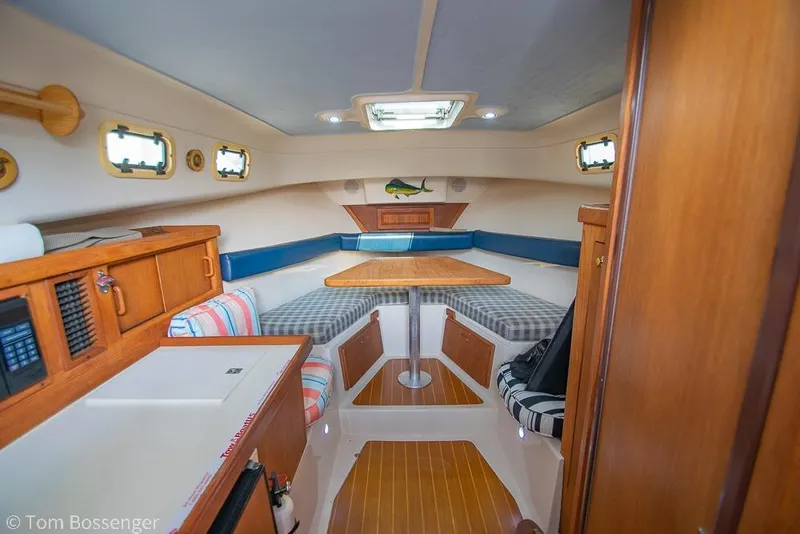 Slide: The Image of Interior of a 1999 Mainship Pilot 30 boat with cozy seating and wooden finishes. - 12