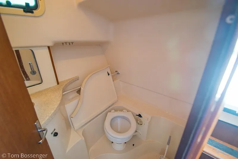Slide: The Image of 1999 Mainship Pilot 30 boat bathroom with toilet and sink, compact and functional design. - 22