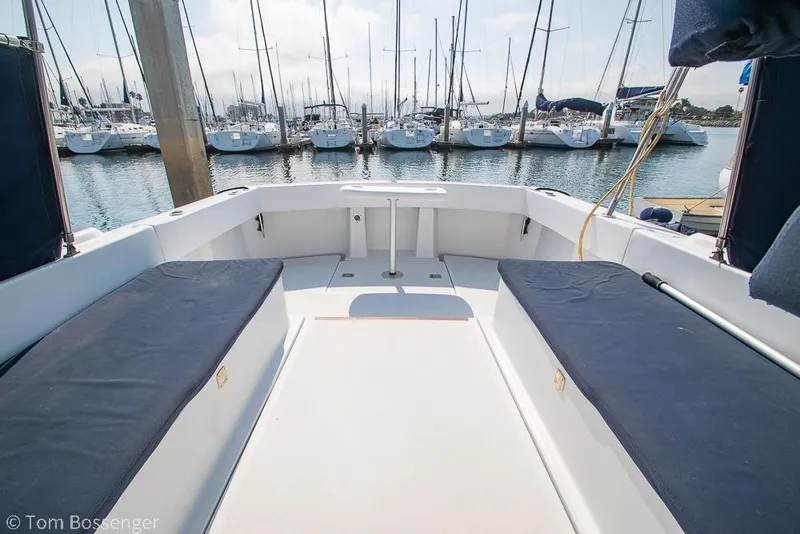 Slide: The Image of 1999 Mainship Pilot 30 boat interior with marina view, featuring cushioned seating and open deck. - 31