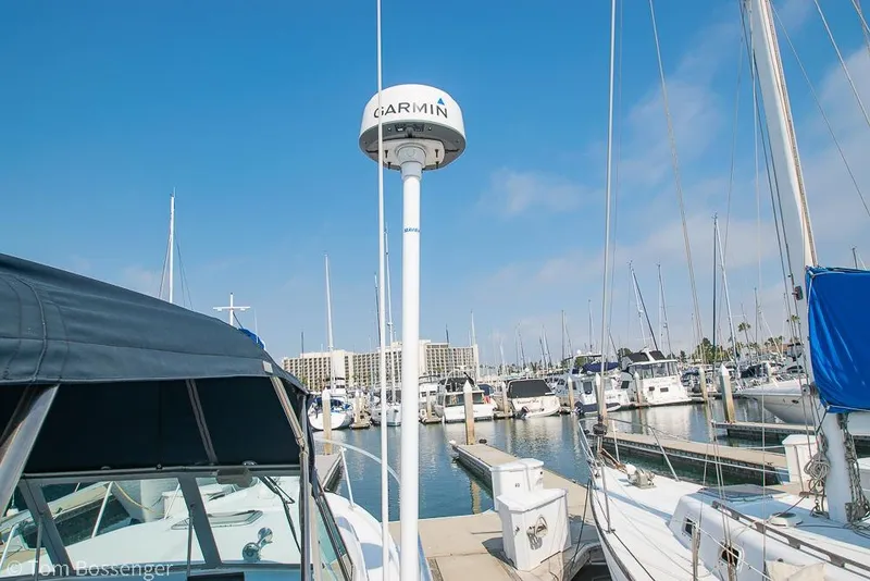 Slide: The Image of 1999 Mainship Pilot 30 docked at marina with Garmin radar, clear blue sky. - 32