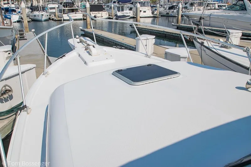 Slide: The Image of 1999 Mainship Pilot 30 boat docked in a marina, showcasing its deck and surroundings. - 34