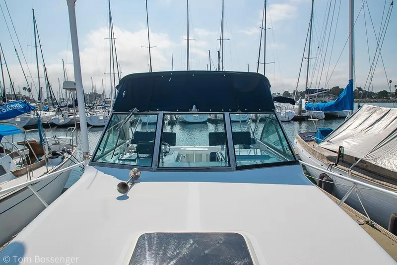 Slide: The Image of 1999 Mainship Pilot 30 docked at marina, surrounded by sailboats. - 36