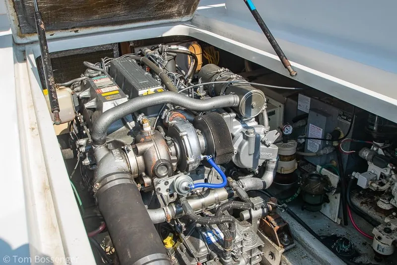Slide: The Image of Engine compartment of a 1999 Mainship Pilot 30 boat, showcasing detailed machinery. - 38