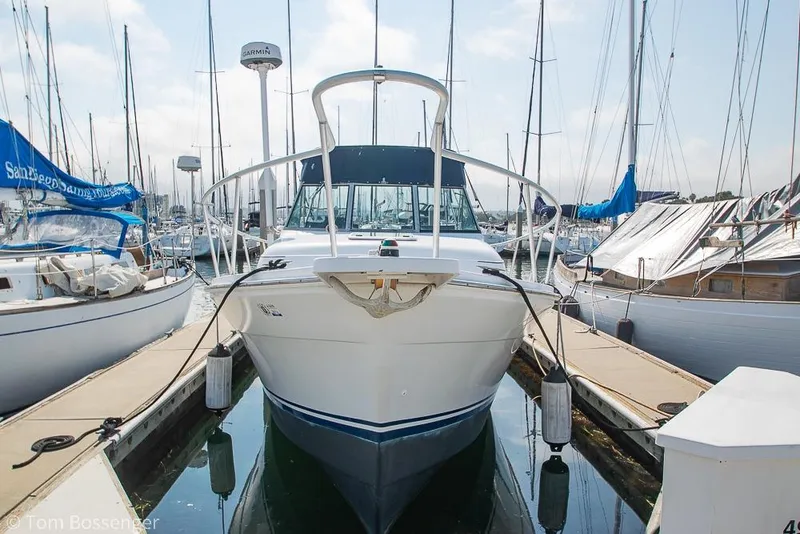 Slide: The Image of 1999 Mainship Pilot 30 docked at a marina, surrounded by sailboats. - 4