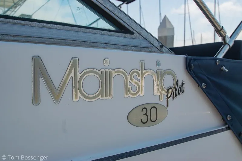 Slide: The Image of 1999 Mainship Pilot 30 boat logo with blue cover and metal frame. - 5