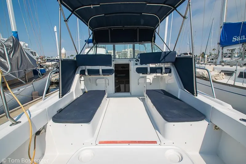 Slide: The Image of 1999 Mainship Pilot 30 boat interior with blue seating, docked at marina. - 8