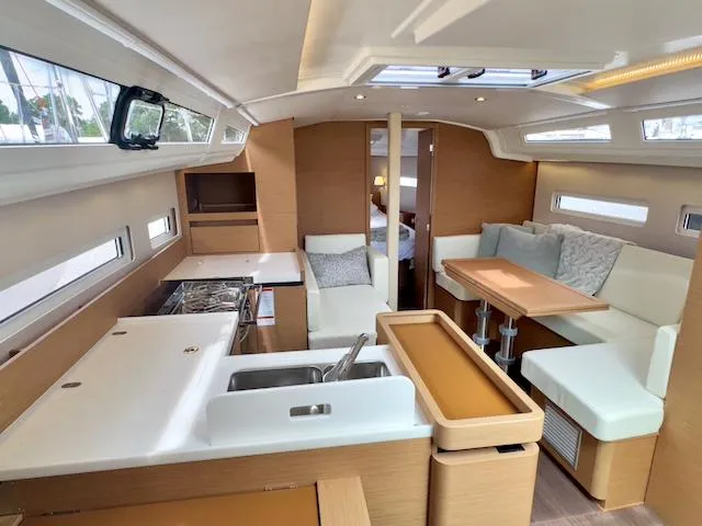 Slide: The Image of 2024 Jeanneau Sun Odyssey 410 interior with modern kitchen and cozy seating area. - 15