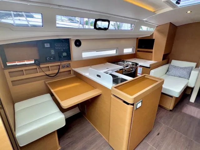 Slide: The Image of Interior of 2024 Jeanneau Sun Odyssey 410 sailboat with modern kitchen and seating area. - 17