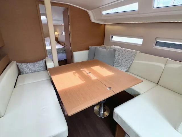 Slide: The Image of Interior of 2024 Jeanneau Sun Odyssey 410, featuring a cozy dining area with cushioned seating. - 22