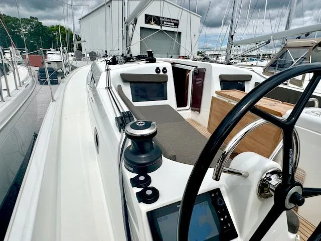 Slide: The Image of 2024 Jeanneau Sun Odyssey 410 sailboat cockpit with steering wheel and winch, docked at marina. - 5