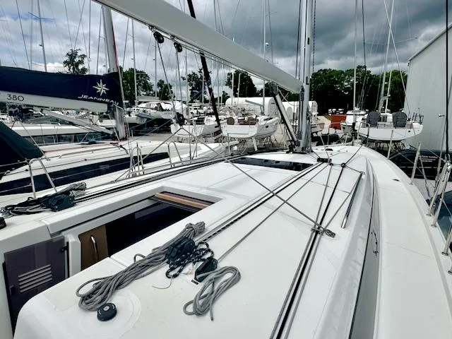 Slide: The Image of 2024 Jeanneau Sun Odyssey 410 sailboat docked in marina, showcasing sleek deck design. - 6