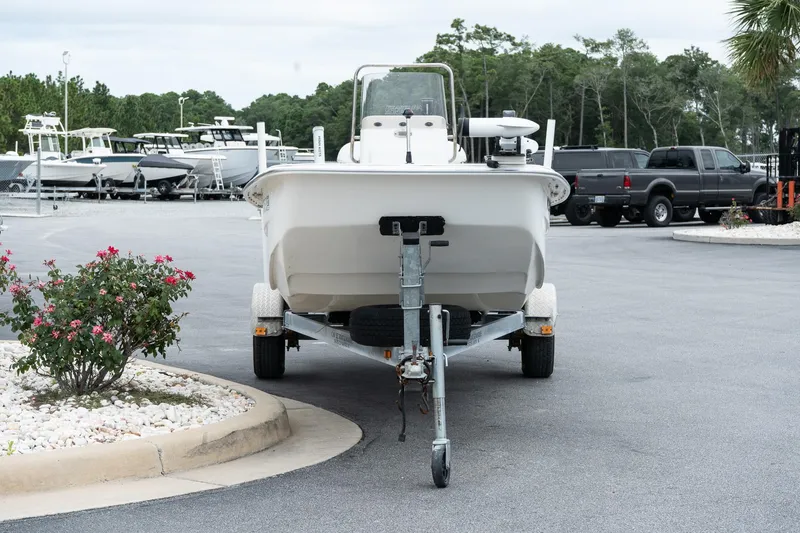 Slide: The Image of 2015 Carolina Skiff 1980 DLX boat on trailer in parking lot, surrounded by trees and vehicles. - 3