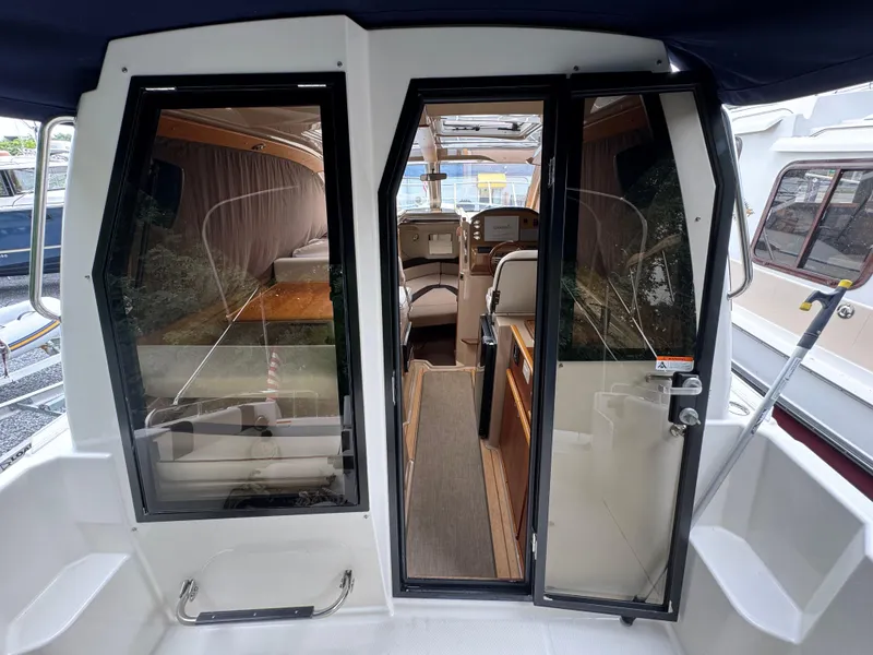Slide: The Image of 2016 Cutwater C-24 boat interior with glass doors, showcasing seating and helm area. - 13