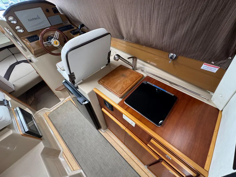 Slide: The Image of Interior of 2016 Cutwater C-24 boat with helm, kitchen area, and seating. - 16