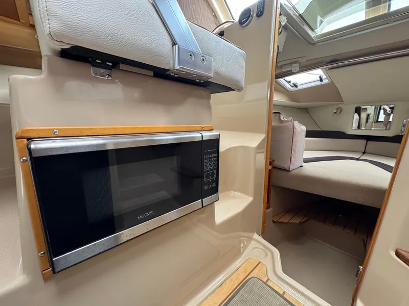 Slide: The Image of Interior of 2016 Cutwater C-24 boat featuring a microwave and cozy seating area. - 19