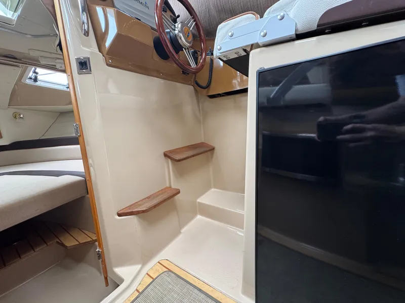 Slide: The Image of Interior of 2016 Cutwater C-24 boat showing helm, steps, and seating area. - 20