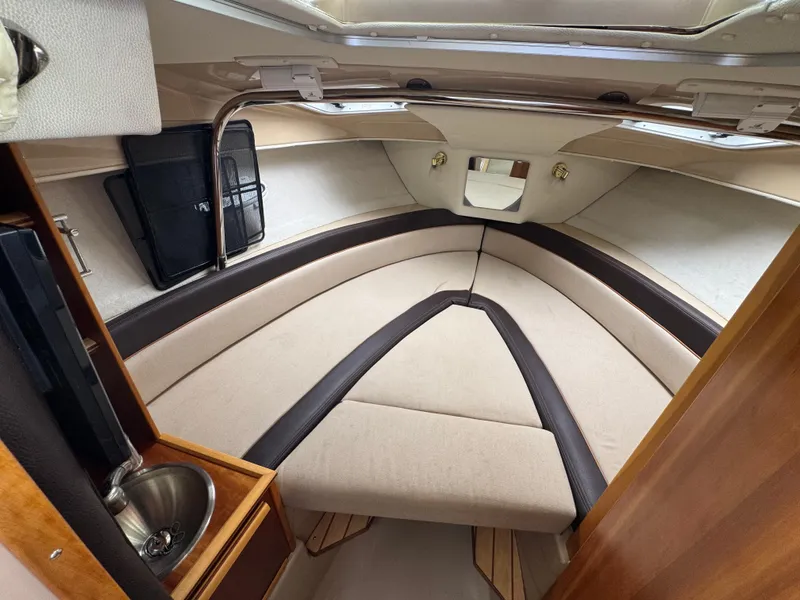 Slide: The Image of 2016 Cutwater C-24 cabin interior with beige seating and compact sink. - 27