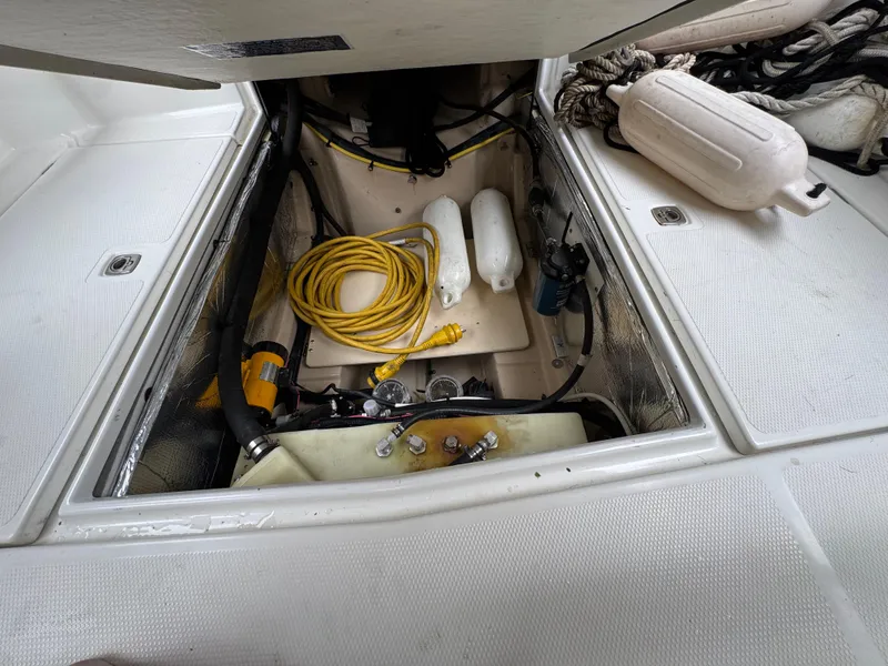 Slide: The Image of 2016 Cutwater C-24 boat storage compartment with ropes, fenders, and coiled yellow cable. - 32