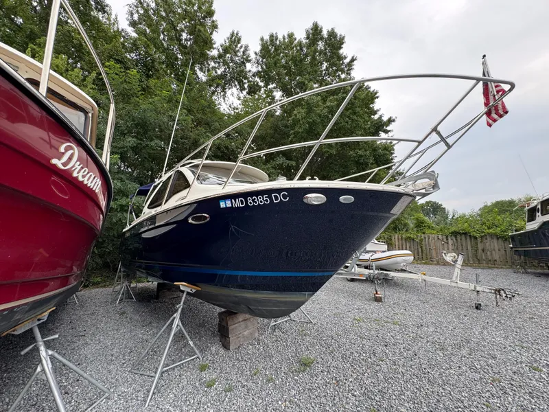 Slide: The Image of 2016 Cutwater C-24 boat on stands, surrounded by trees and gravel. - 6