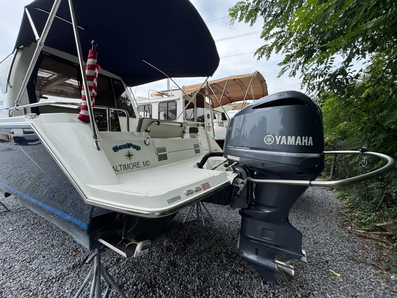 Slide: The Image of 2016 Cutwater C-24 boat with Yamaha outboard motor, parked on gravel, featuring a canopy. - 7