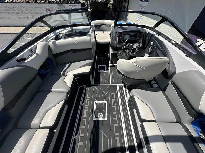 Slide: The Image of Interior of a 2021 Centurion Fi23 boat with gray seating and modern dashboard. - 17