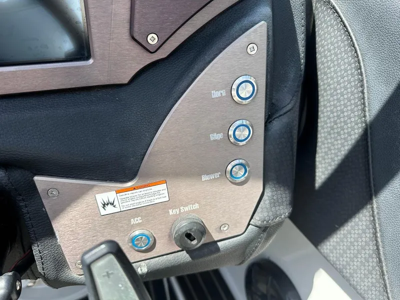 Slide: The Image of Control panel of a 2021 Centurion Fi23 boat with labeled buttons and key switch. - 23
