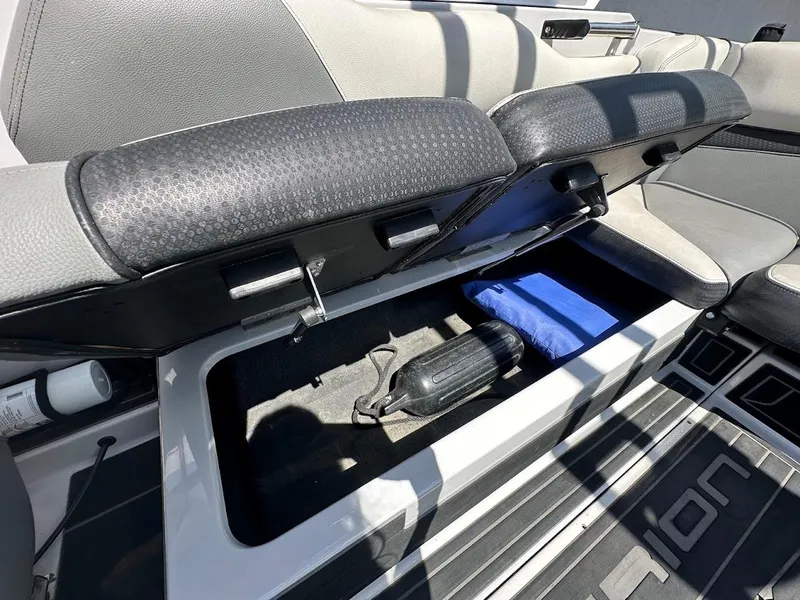 Slide: The Image of 2021 Centurion Fi23 boat storage compartment with open seat, revealing interior space and accessories. - 35