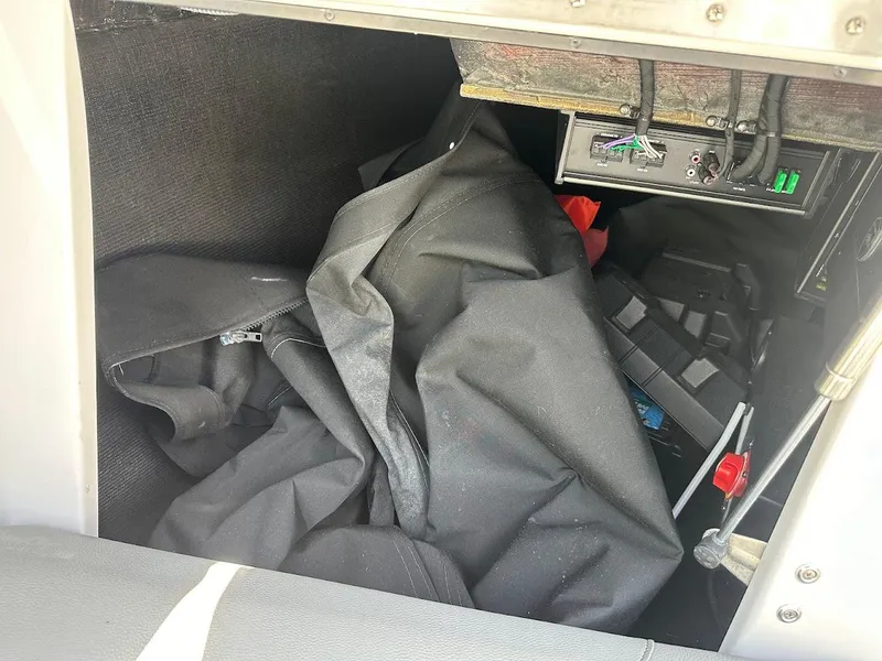 Slide: The Image of Interior storage compartment of a 2021 Centurion Fi23 boat with equipment and cables. - 38