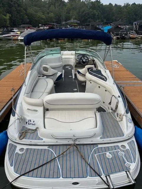 Slide: The Image of 2008 Crownline 240 EX boat docked on a lake with seating and canopy. - 2