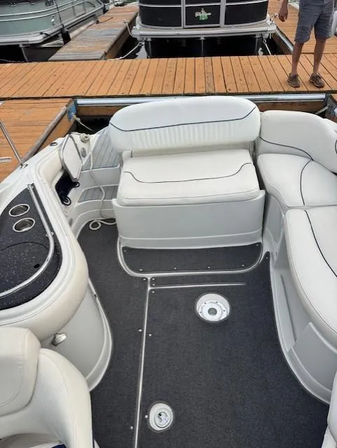 Slide: The Image of 2008 Crownline 240 EX boat interior with white seating and cup holders at a dock. - 3
