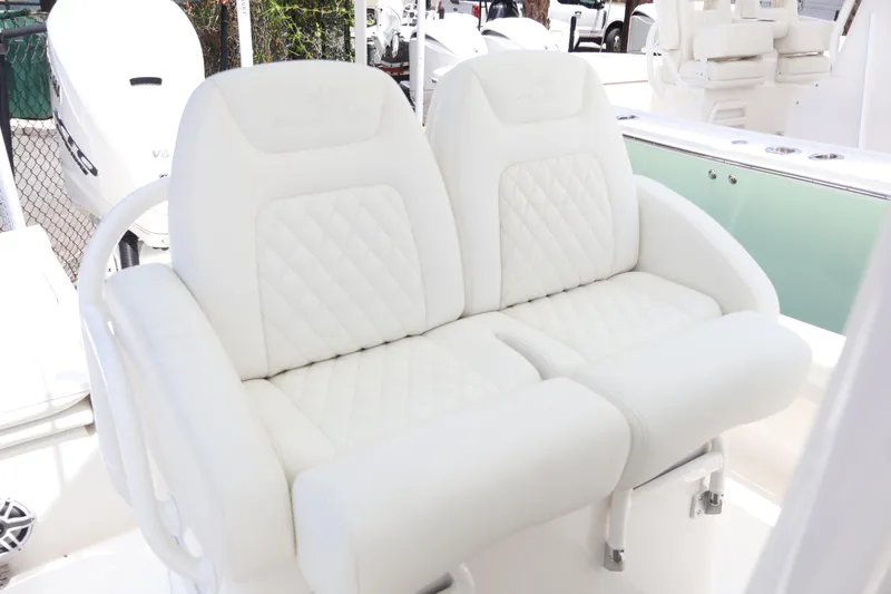 Slide: The Image of Luxurious white seating on 2025 Regulator 26XO boat, featuring quilted design and armrests. - 14