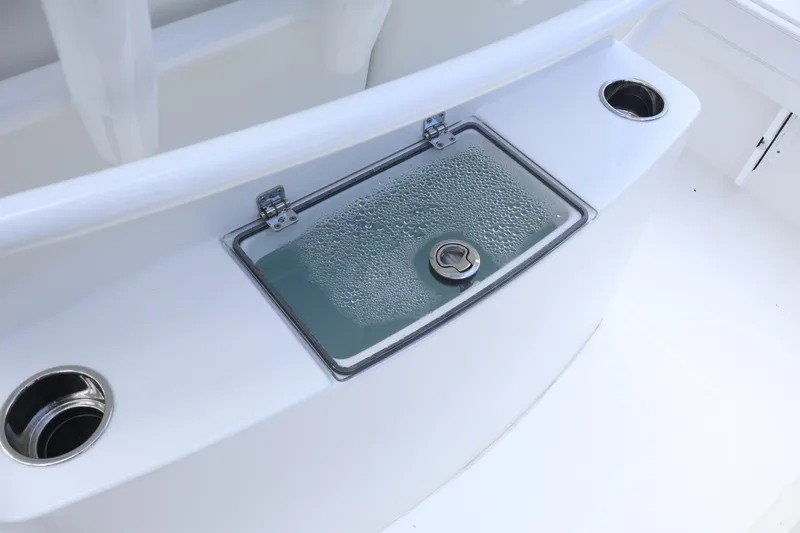 Slide: The Image of 2025 Regulator 26XO boat with a closed livewell and cup holders. - 17