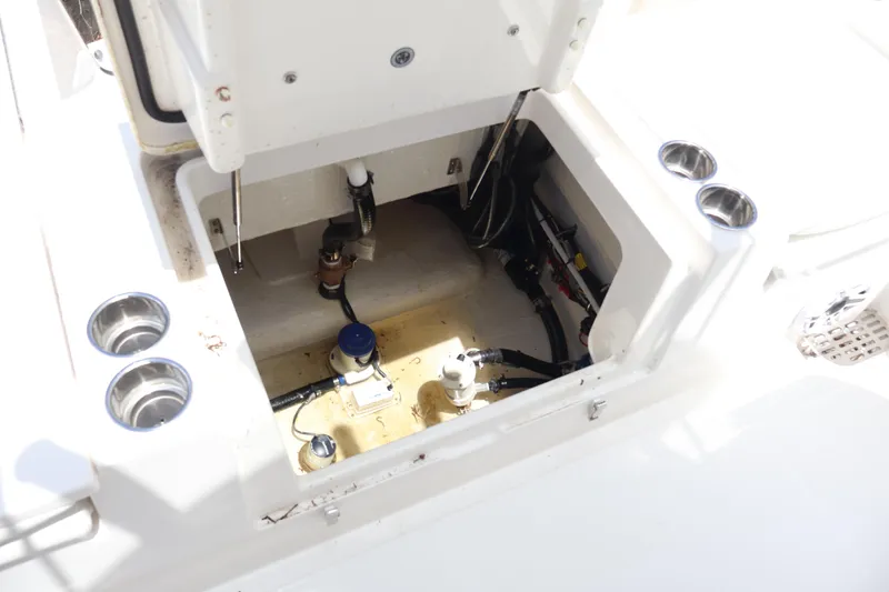Slide: The Image of Open compartment of 2025 Regulator 26XO boat showing internal components and cup holders. - 19