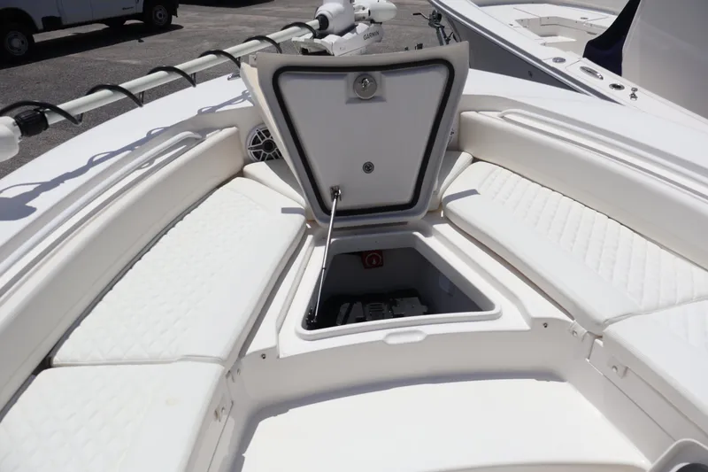 Slide: The Image of 2025 Regulator 26XO boat with open storage compartment and cushioned seating. - 6