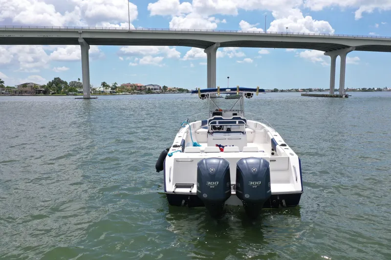 Slide: The Image of 2000 Stamas 290 Tarpon boat with twin engines on the water near a bridge. - 1