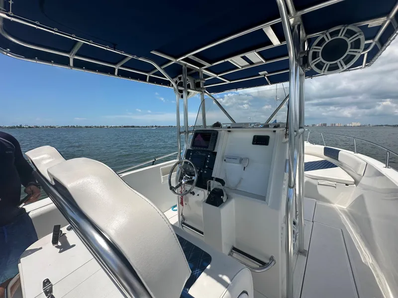 Slide: The Image of 2000 Stamas 290 Tarpon boat interior with steering console and blue canopy. - 16