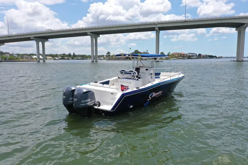 Slide: The Image of 2000 Stamas 290 Tarpon boat on water near a bridge, clear sky background. - 2