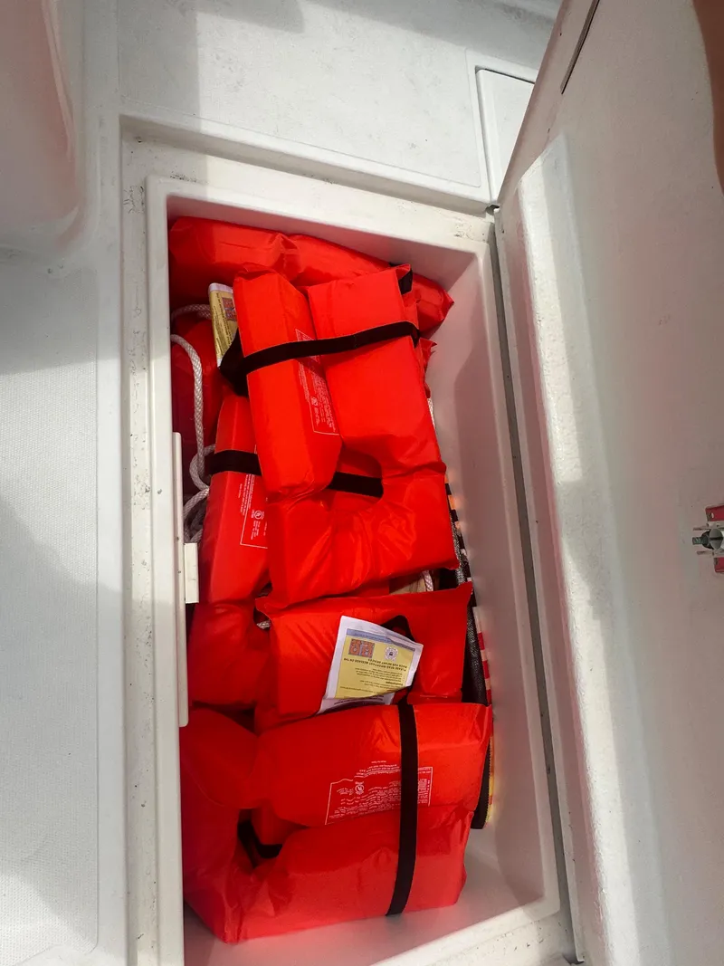 Slide: The Image of Life jackets stored in a compartment on a 2000 Stamas 290 Tarpon boat. - 30