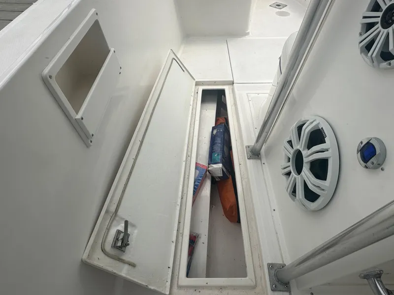 Slide: The Image of Storage compartment on a 2000 Stamas 290 Tarpon boat with speakers and safety equipment. - 32