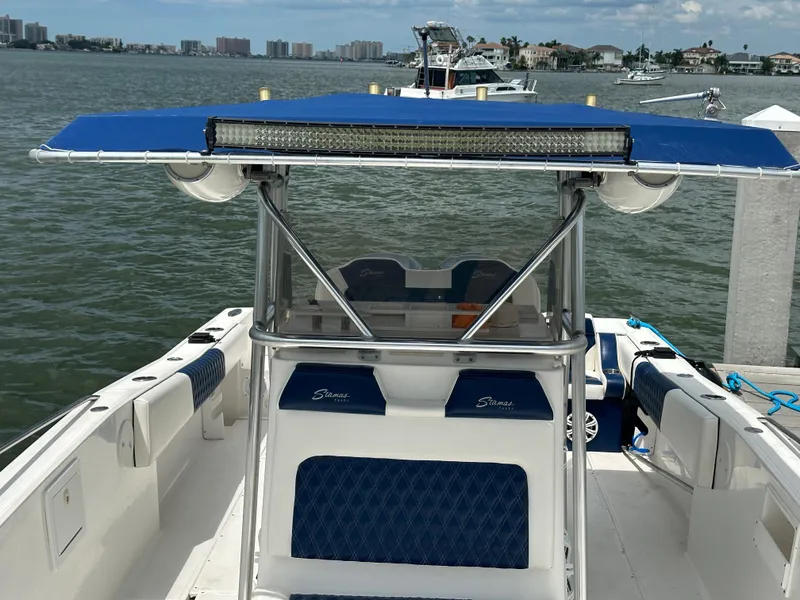 Slide: The Image of 2000 Stamas 290 Tarpon boat with blue canopy docked by the water. - 35