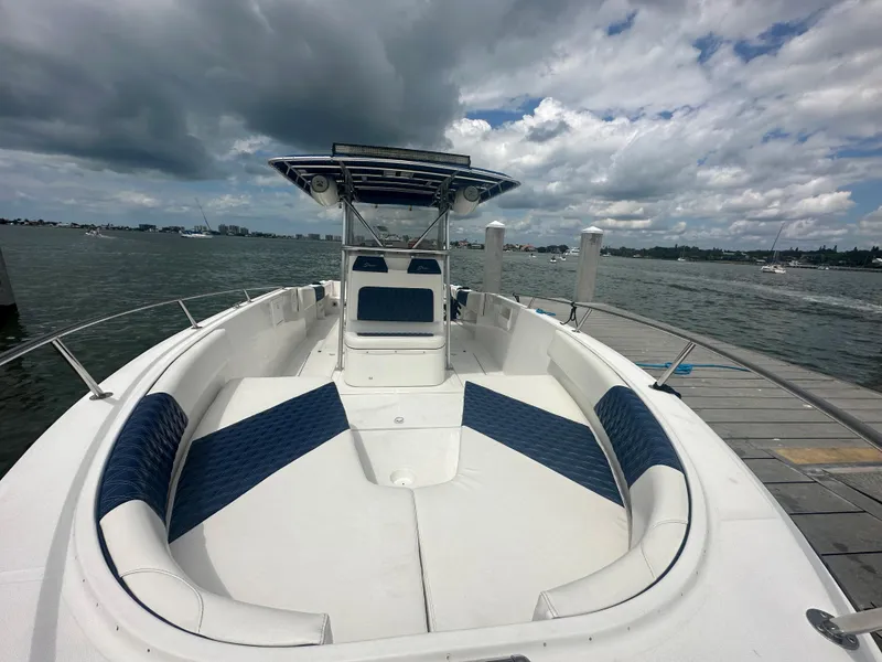 Slide: The Image of 2000 Stamas 290 Tarpon boat docked, featuring spacious seating and a T-top under cloudy skies. - 37