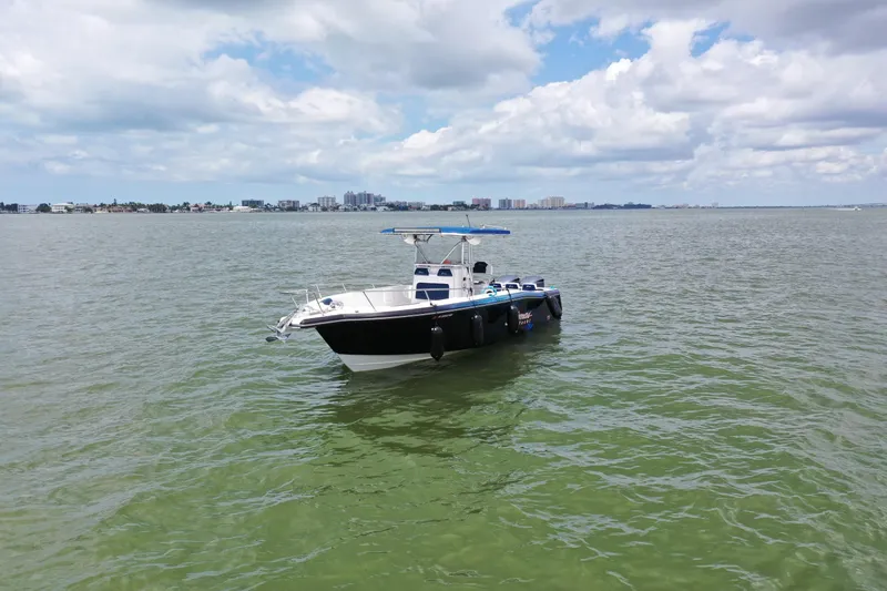 Slide: The Image of 2000 Stamas 290 Tarpon boat on calm waters with city skyline in the background. - 4
