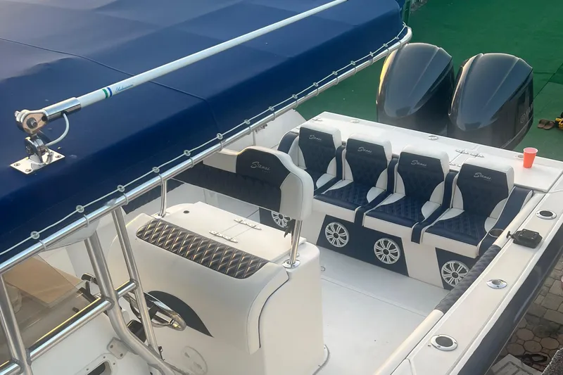 Slide: The Image of 2000 Stamas 290 Tarpon boat with blue canopy and seating, dual outboard motors. - 47