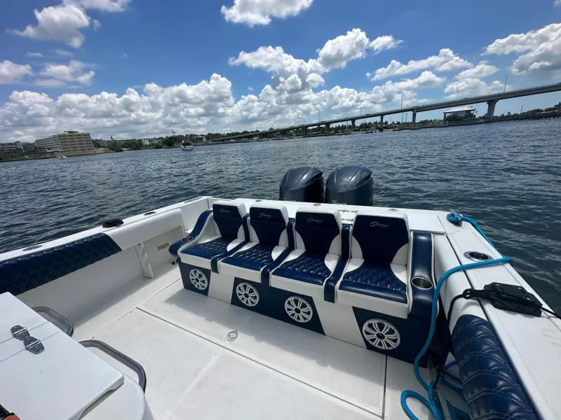 Slide: The Image of Stamas 290 Tarpon 2000 boat with blue seating, twin engines, and scenic waterfront view. - 9