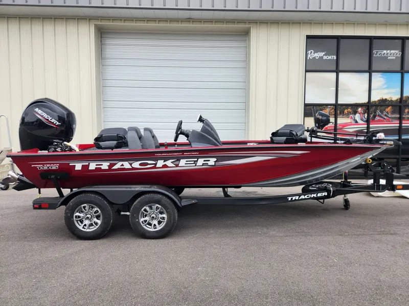 The Image of 2026 Tracker Pro Team 195 boat, red, on trailer outside a building. - 0